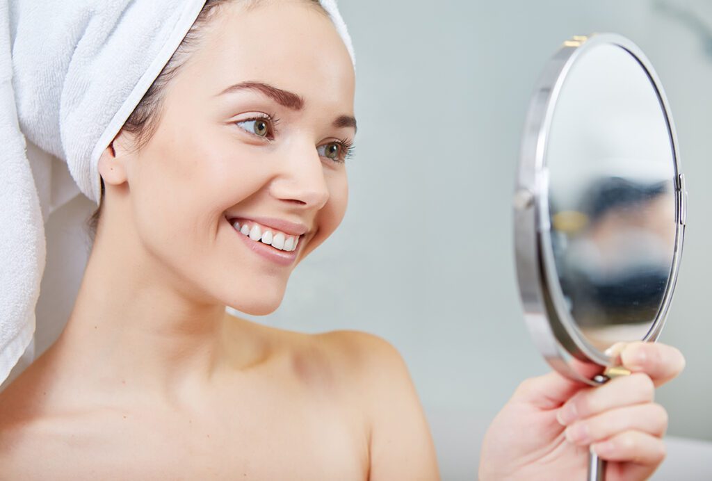 health and wellness products - a woman looking at herself in the mirror