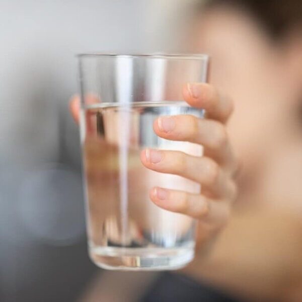 a woman holding a glass of water - qnet water purifier